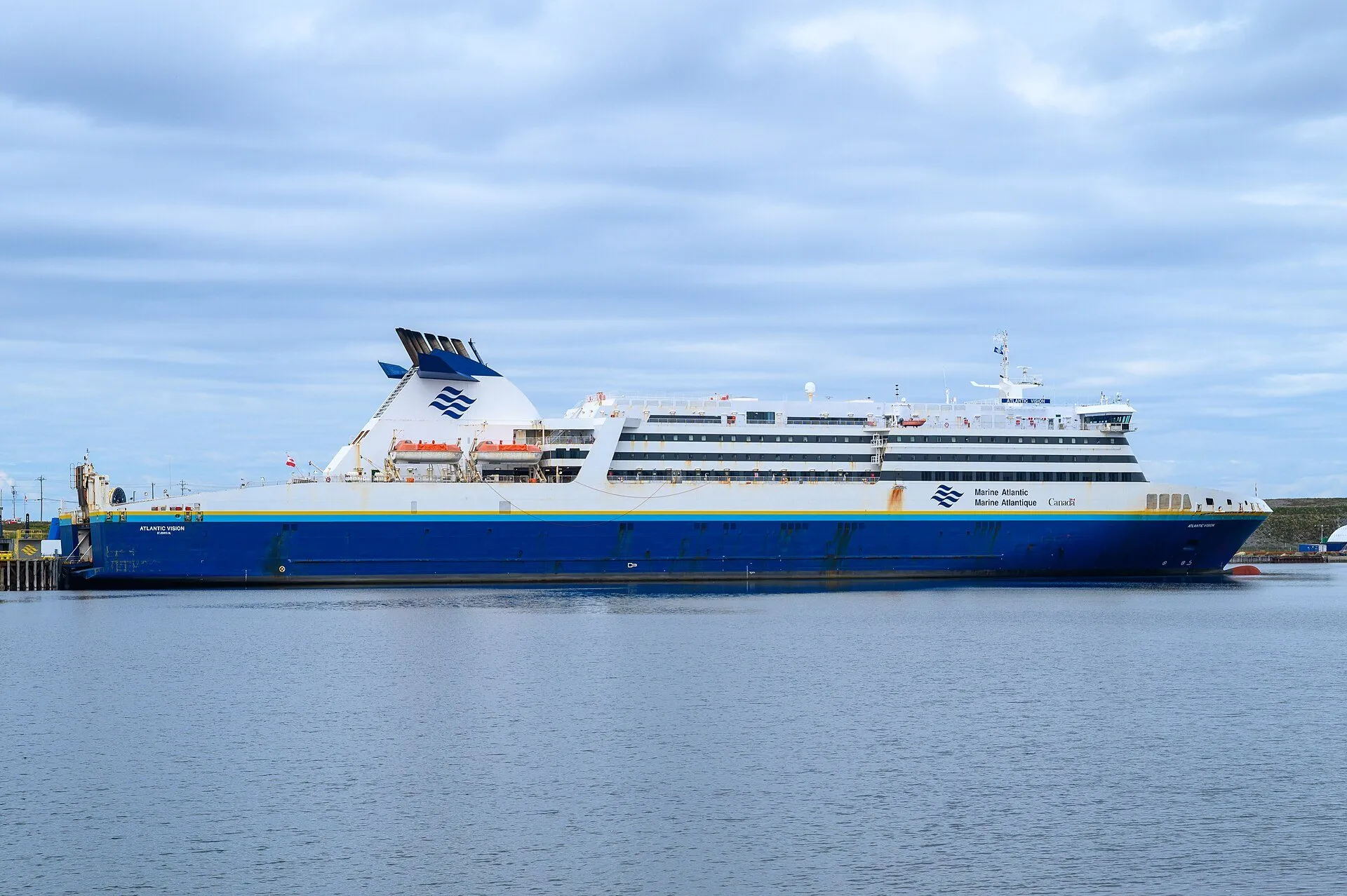 The Marine Atlantic ferry Atlantic Vision berthed at the Argentia terminal on a calm, cloudy day.
