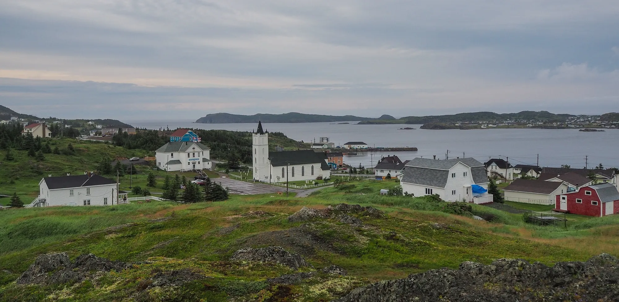 Twillingate church and houses over the harbour, overcast.