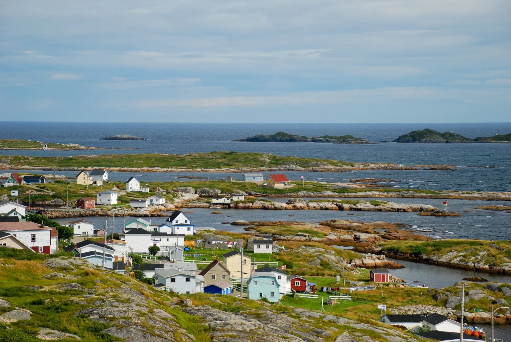 Lookout view over Greenspond's houses, rocky islands and open sea.